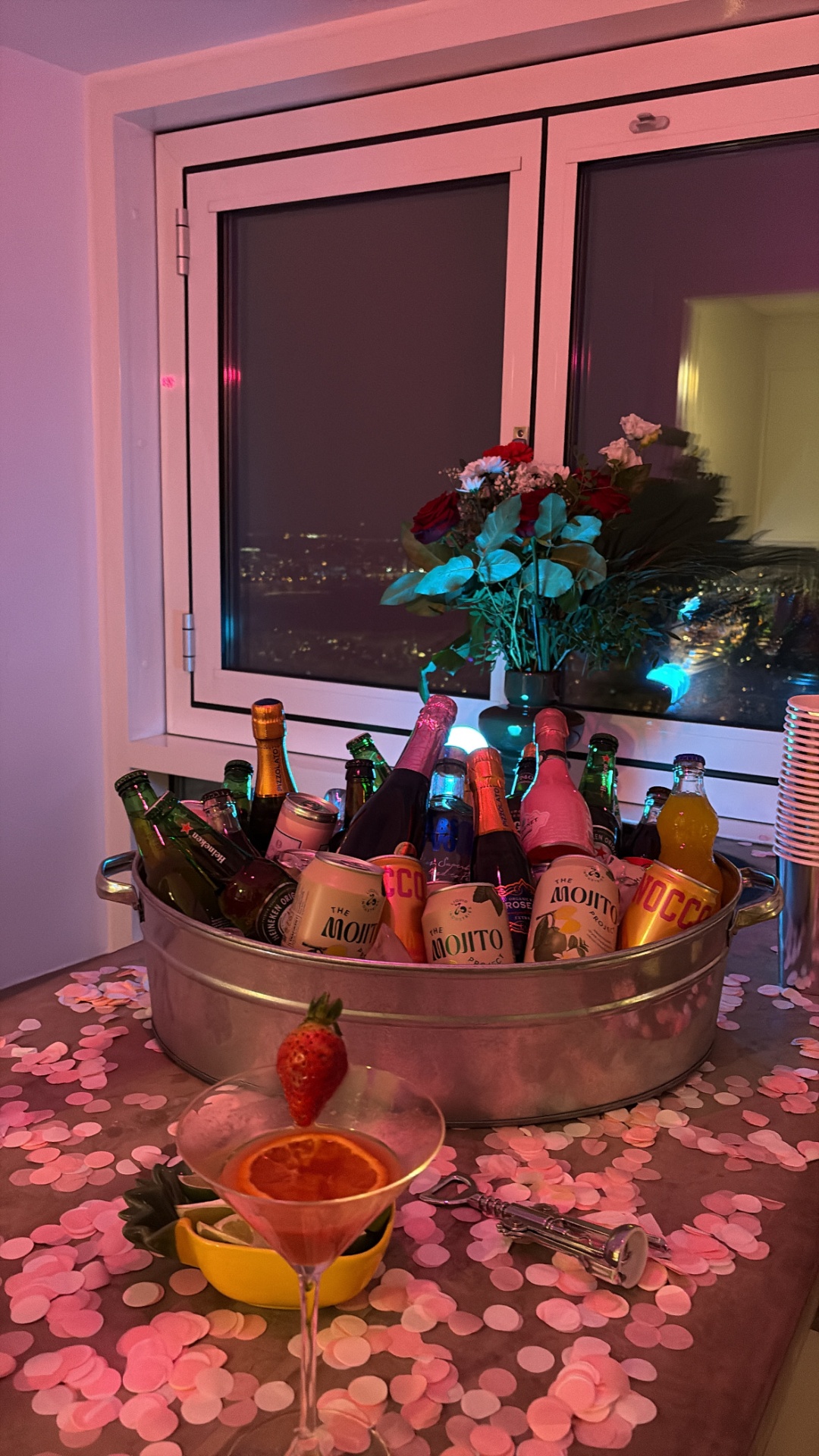 Din Tanovic — Stockholm birthday drinks bucket by the window, pink confetti and city lights