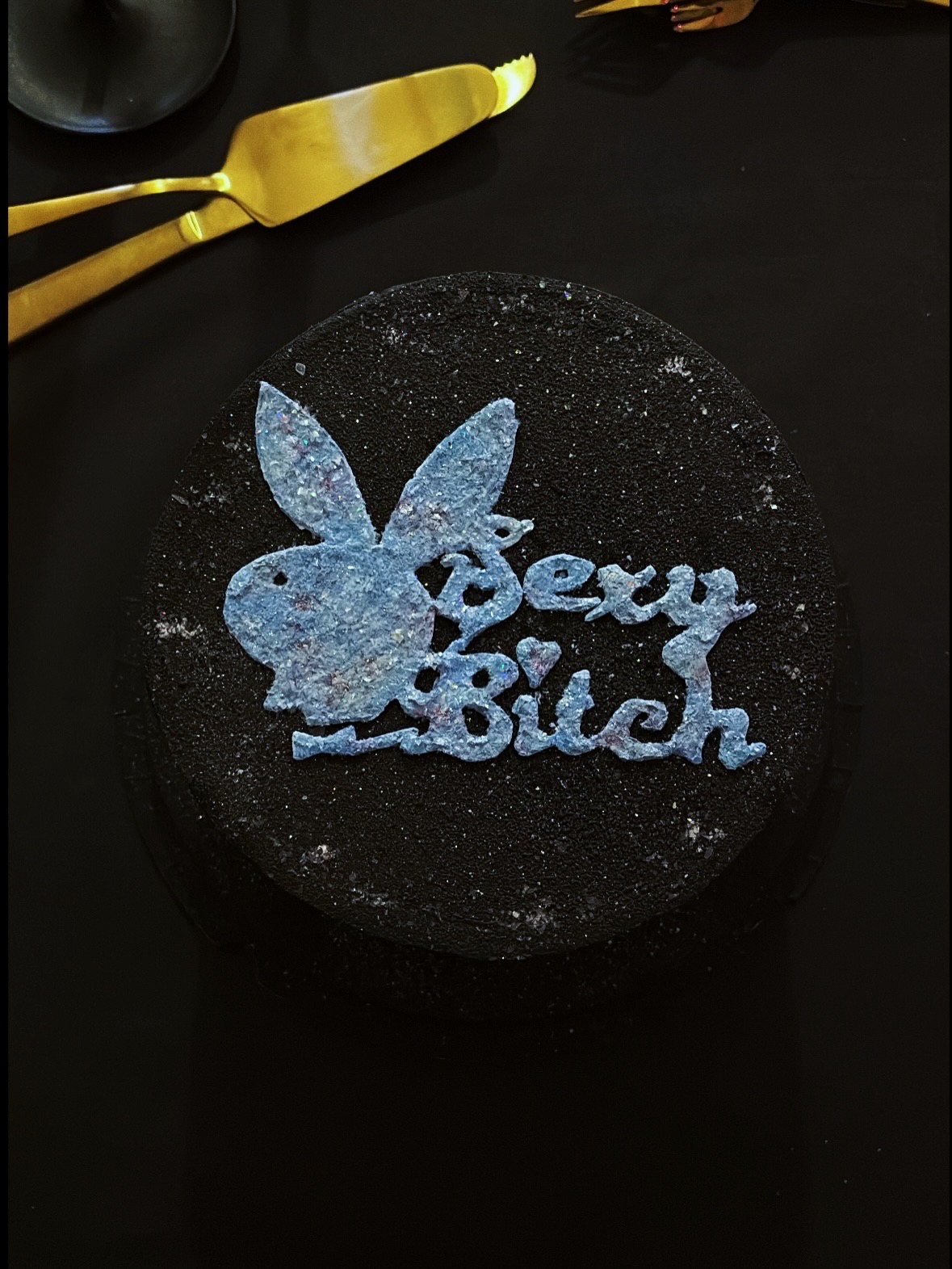 Din Tanovic — close-up of the 'Sexy Bitch' bunny topper on a black glitter birthday cake
