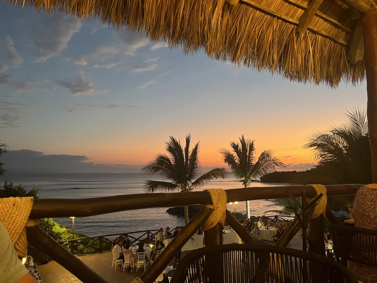 Sunset over the sea under a thatched roof — from Din Tanovic's travel mood collection