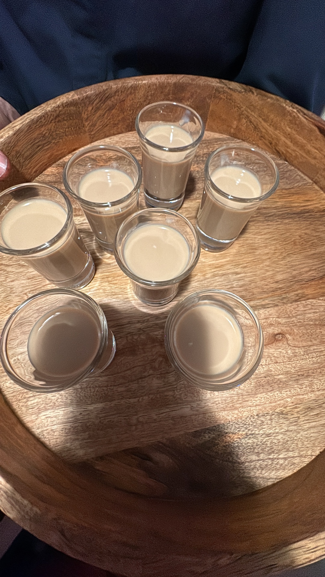 Din Tanovic — tray of Baileys shots on dark wood at a Stockholm birthday party