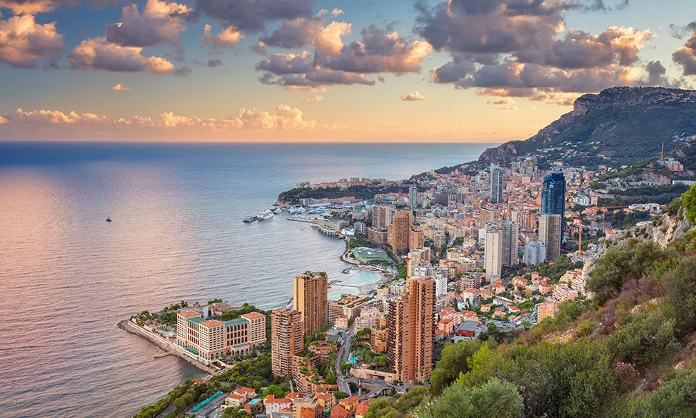 Din Tanovic — Monaco coastline at golden hour, soft clouds over the Mediterranean